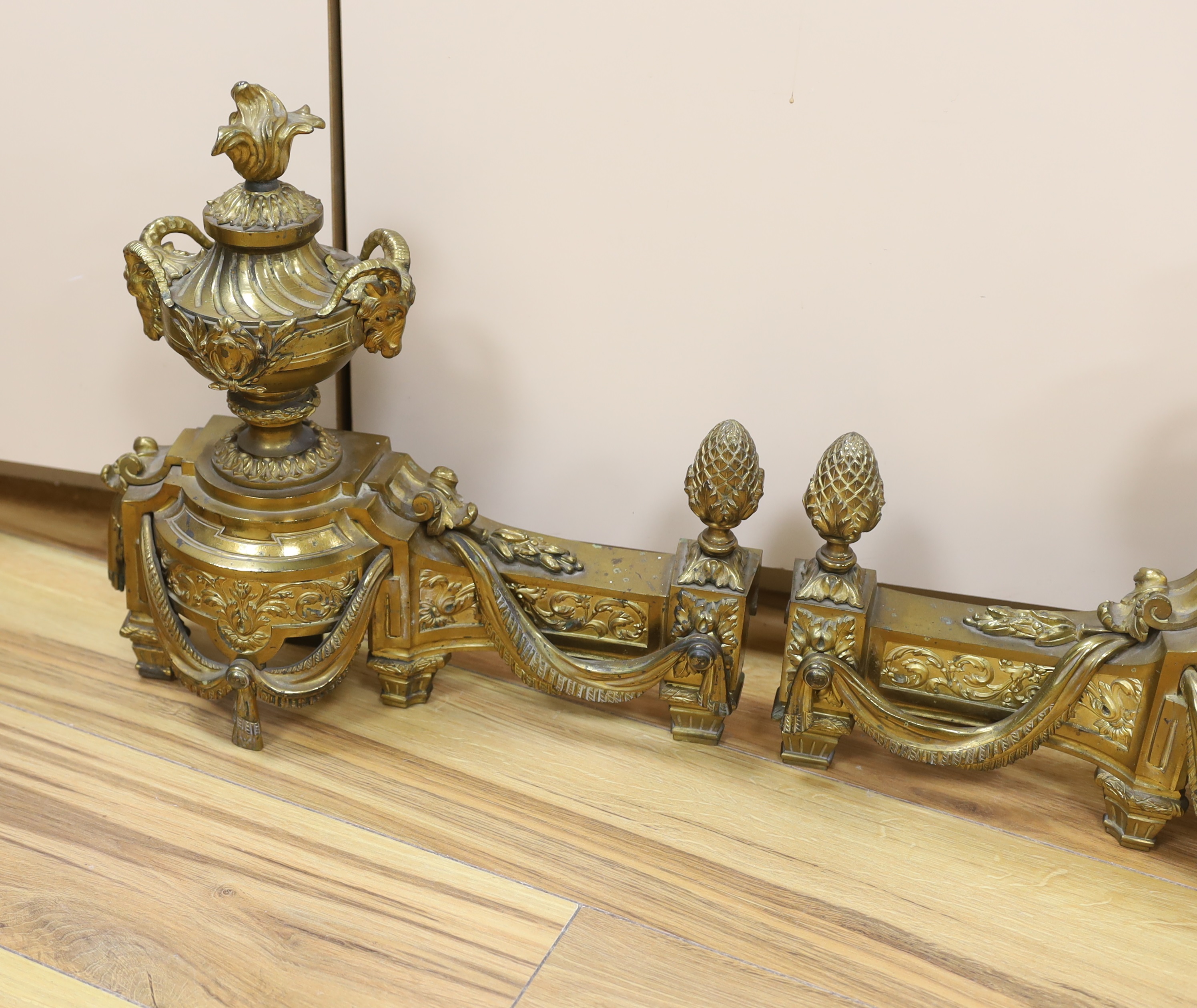 A French gilt bronze pair of urn shaped chenet, 39cm wide